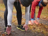Twee mensen doen samen sportoefeningen in een bosrijke omgeving.