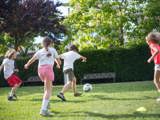 Kindere voetballen buiten.