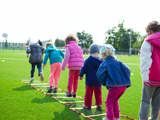 Kinderen springen tijdens buitensportoefening.